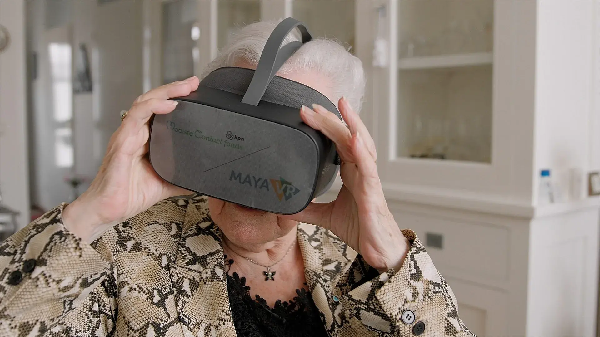 Oudere dame met een VR bril op kan kijken naar rondleiding Rijksmuseum