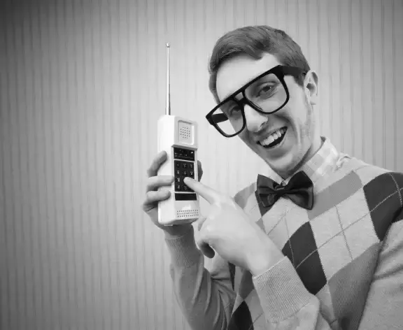 Man met grote bril heeft een vande eerste draadloze telefoons in handen