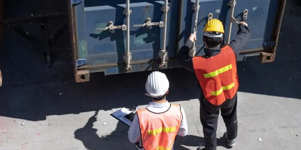 Werkende mannen met veiligheidskleding aan maken container open