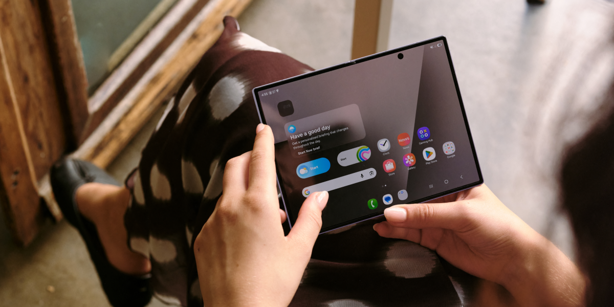 Vrouw gebruikt de opengevouwen Samsung Galaxy Z Fold8 zittend