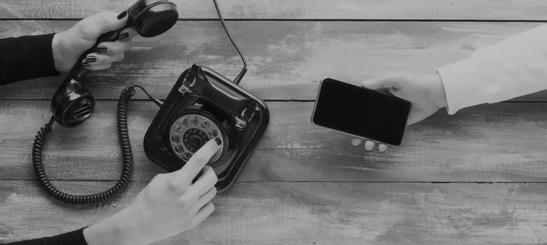 links de oude draai telefoon en rechts een hand met een mobiele telefoon