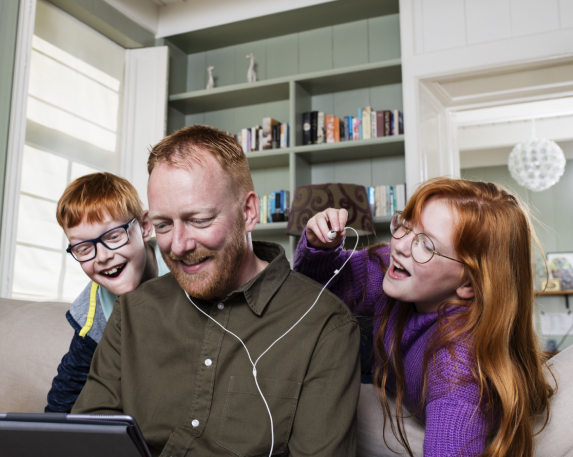 Vader met 2 kinderen kijken naar een tablet scherm
