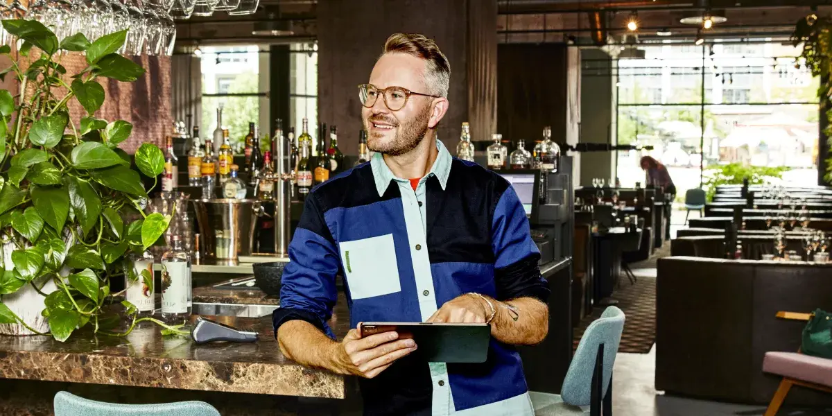 Een mannelijke horeca-ondernemer staat aan de bar in een restaurant
