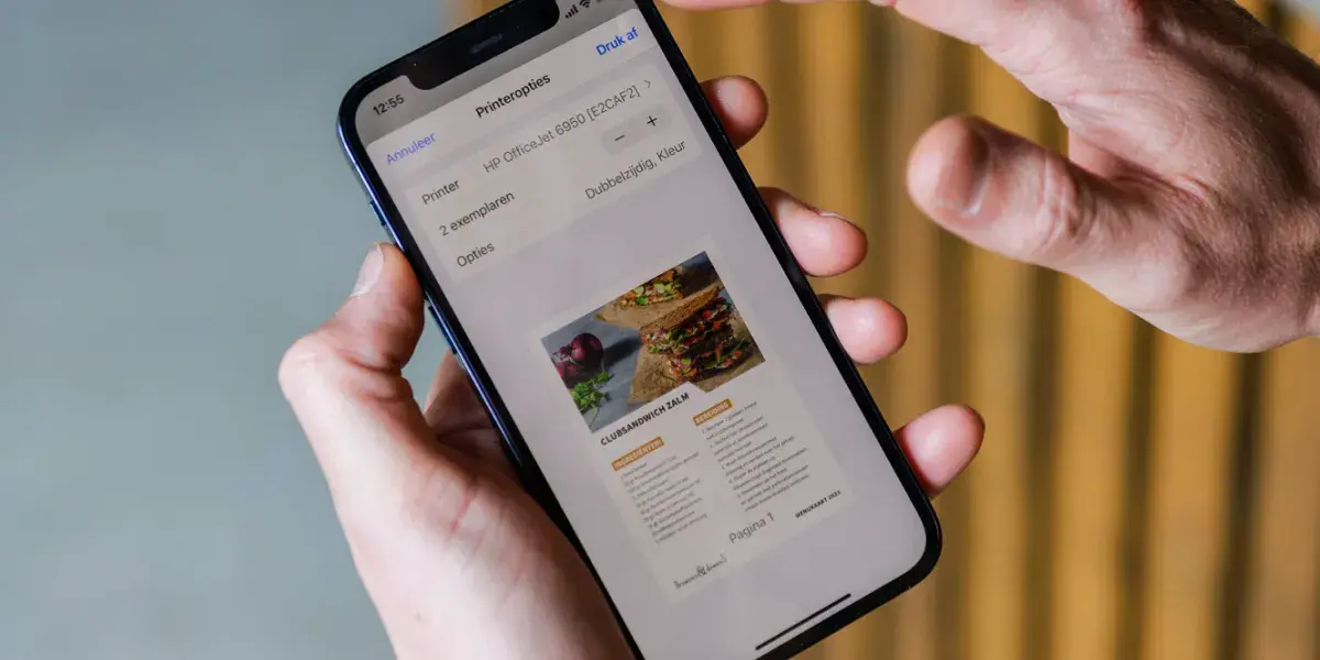 Mobiel in handen met daarop printopties te zien 
