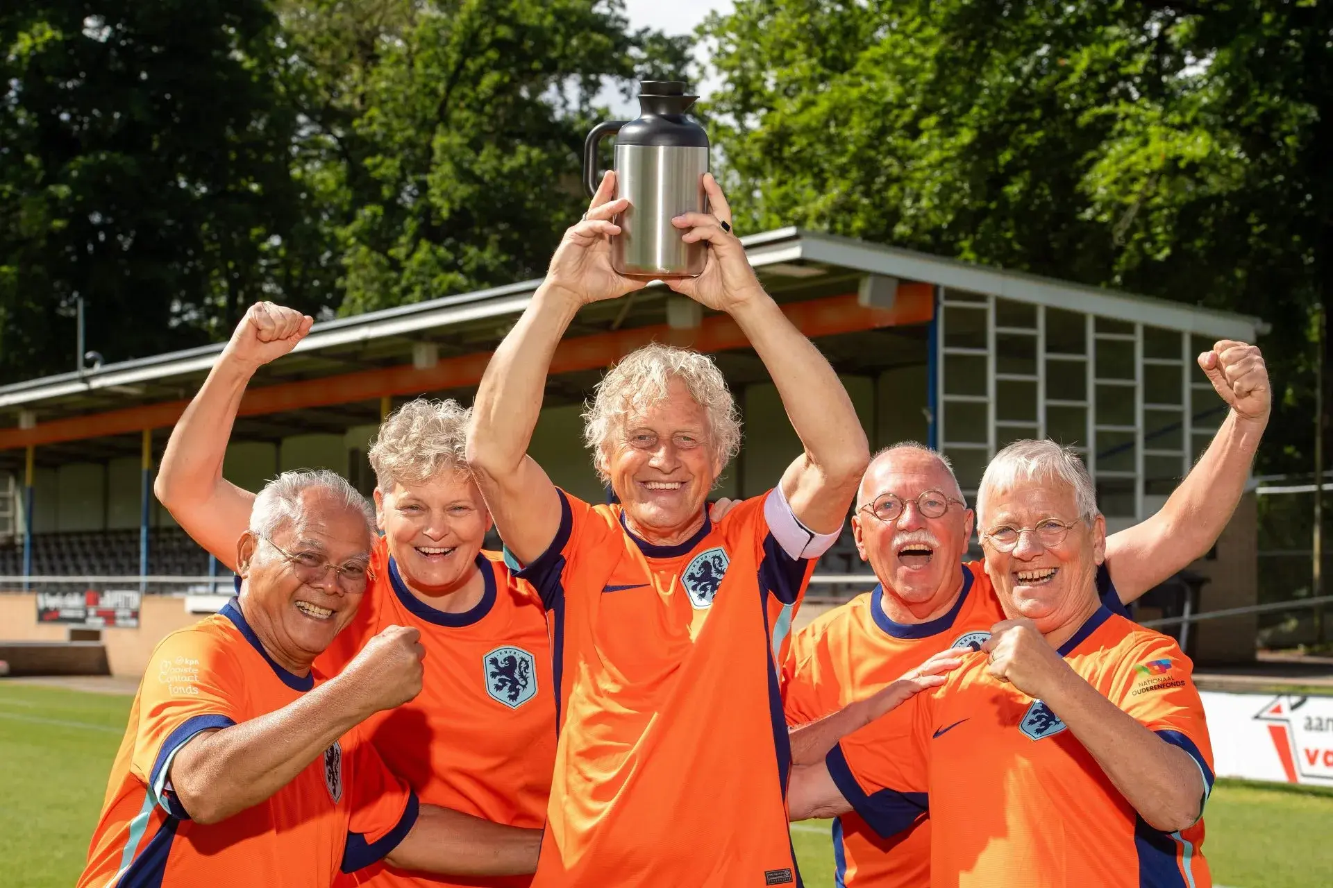 Spelers Walking Football met de winnende beker omhoog in handen