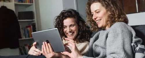 2 vrouwen lachend kijkend naar iPad