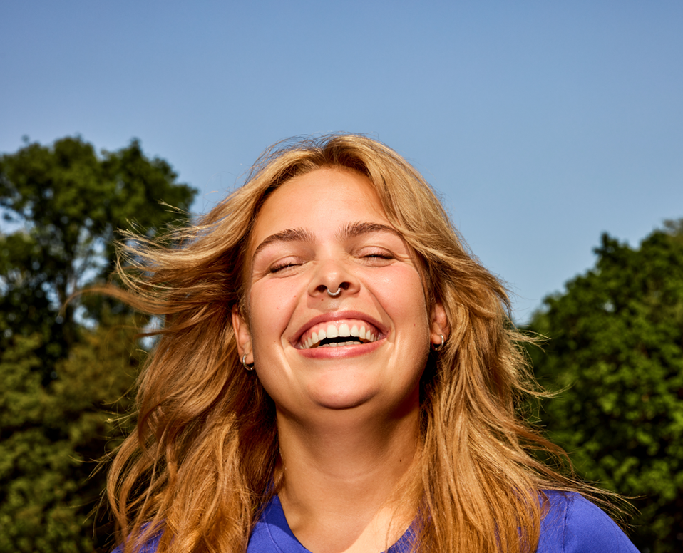 Blije vrouw met uitgesproken lach op haar gezicht.