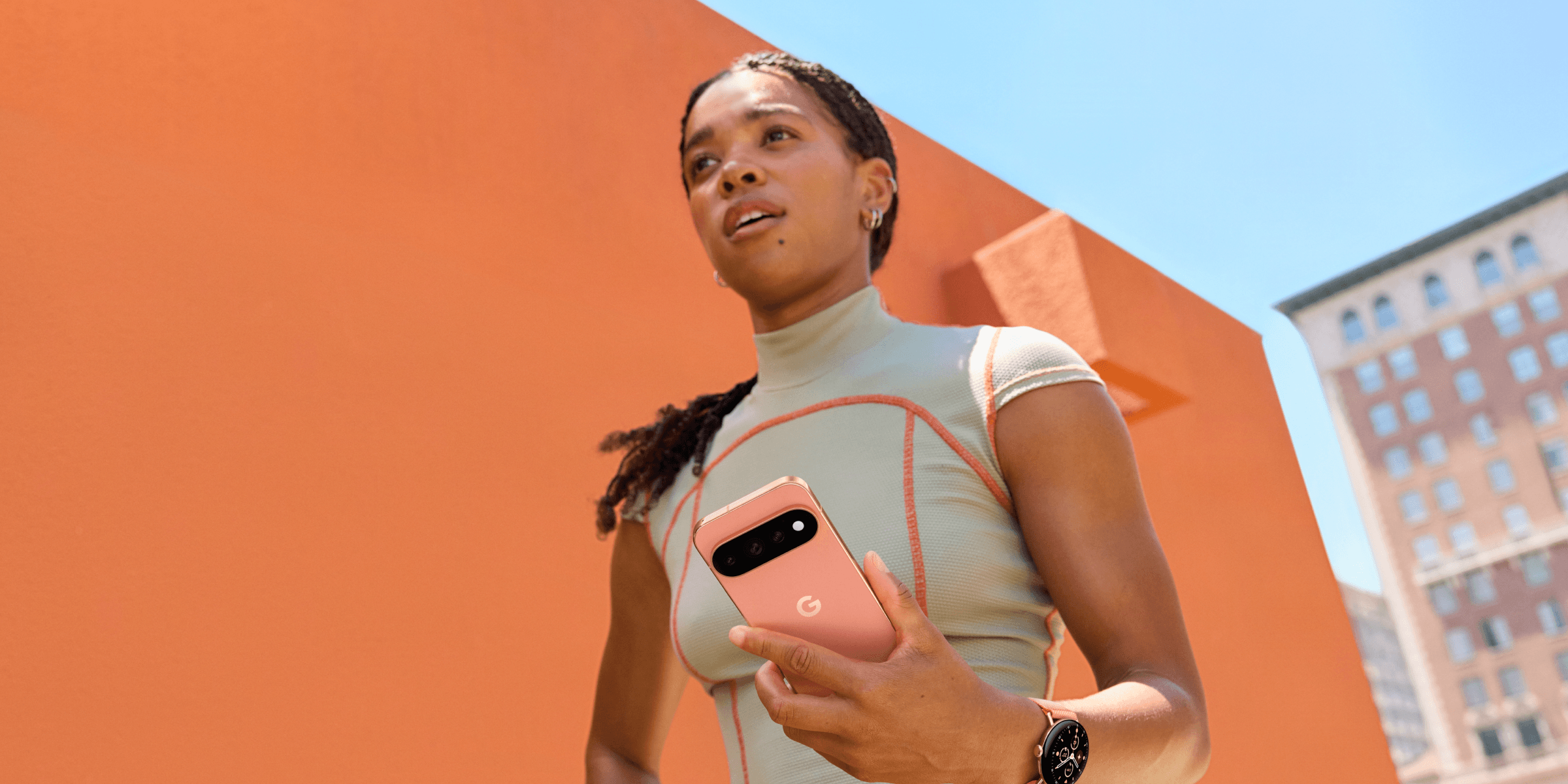 Vrouw houdt oranje Google Pixel 11 Pro XL vast in haar hand