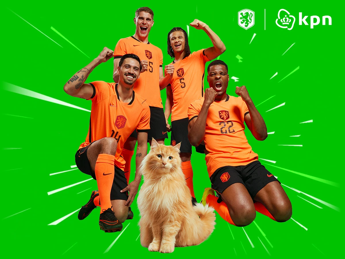Tijjani Reijnders, Micky van de Ven, Nathan Aké en Denzel Dumfries in WK 2026 Oranjetenue met Louis de kat op een groene achtergrond met witte SuperFiber-strepen en rechtsboven de KNVB en KPN logo's