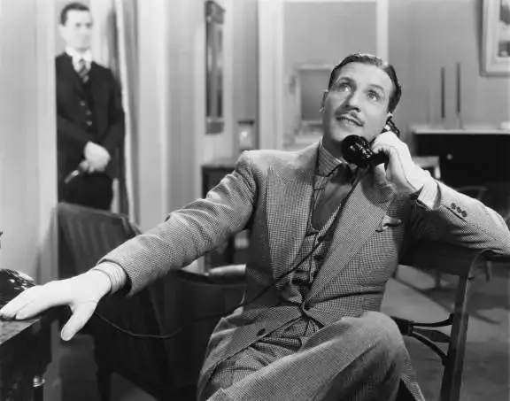 man zittend in ee nstoel aan het telefoneren met een vaste telefoon