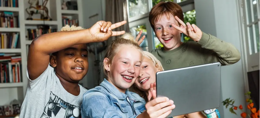 Vier kinderen achter tablet