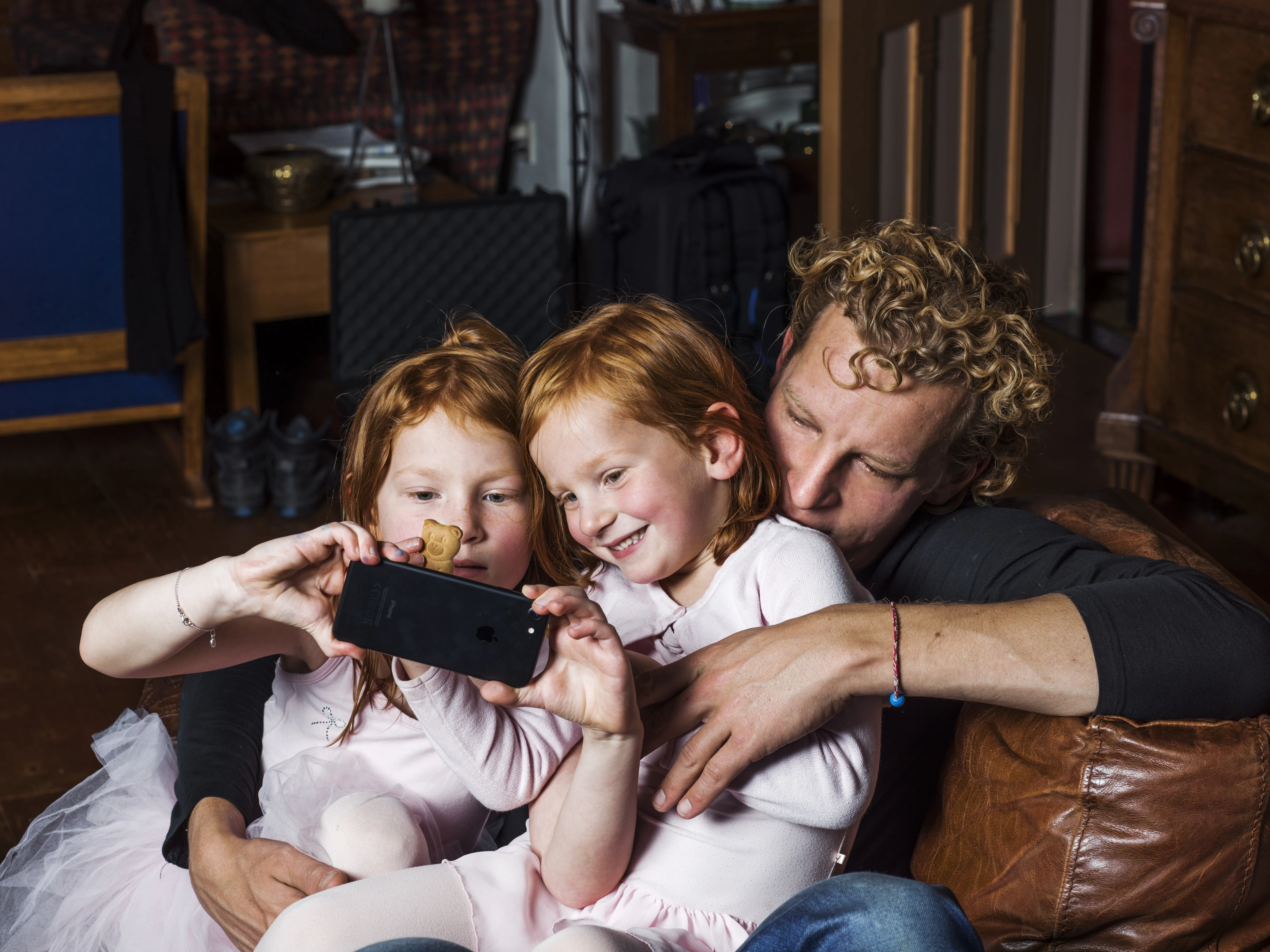 Vader en kinderen kijken naar smartphone scherm