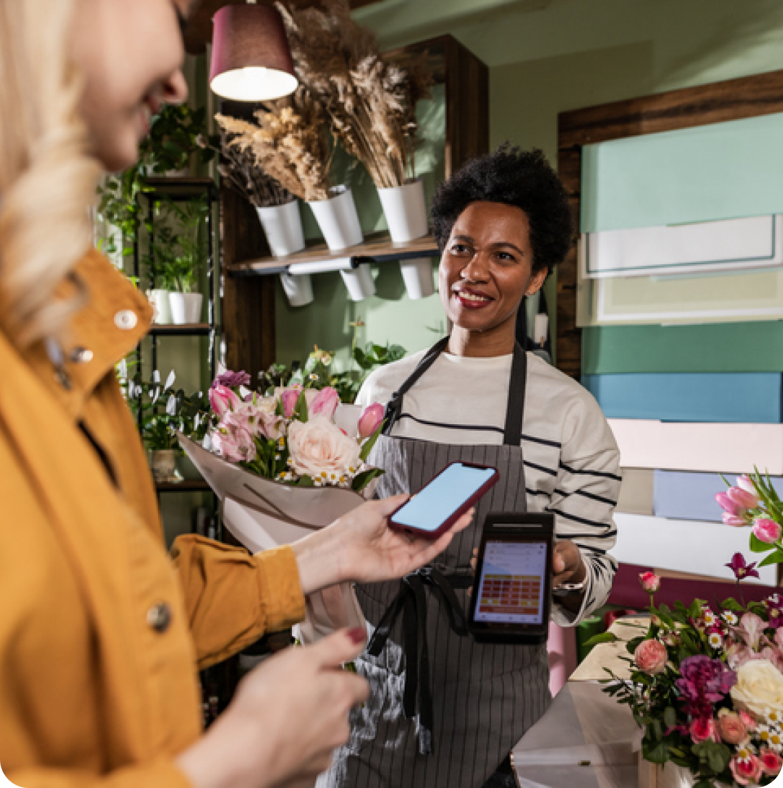 Klant rekent contactloos af in een bloemenwinkel. 