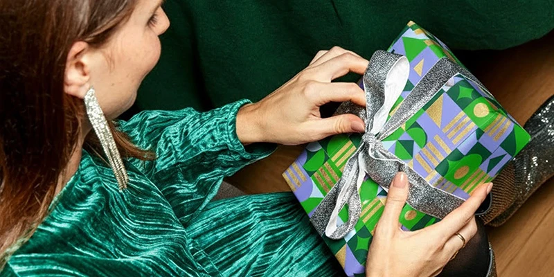 Vrouw pakt een cadeautje uit