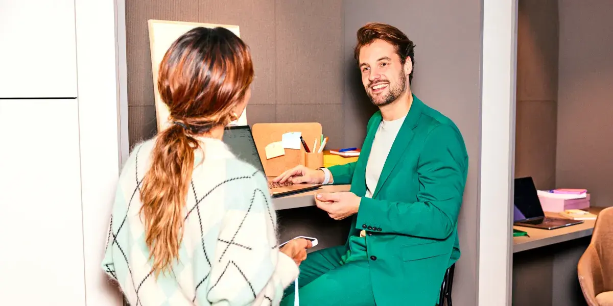 Een mannelijke en vrouwelijke collega zijn met elkaar in overleg op kantoor. 