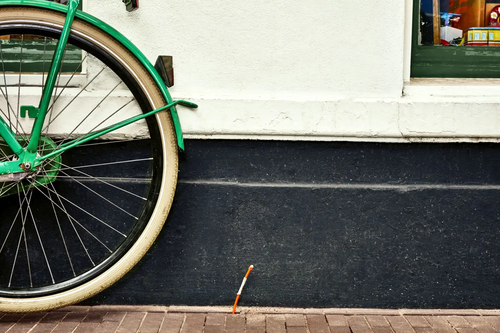 Glasvezeldraad van KPN loopt uit de straat omhoog naast een fiets