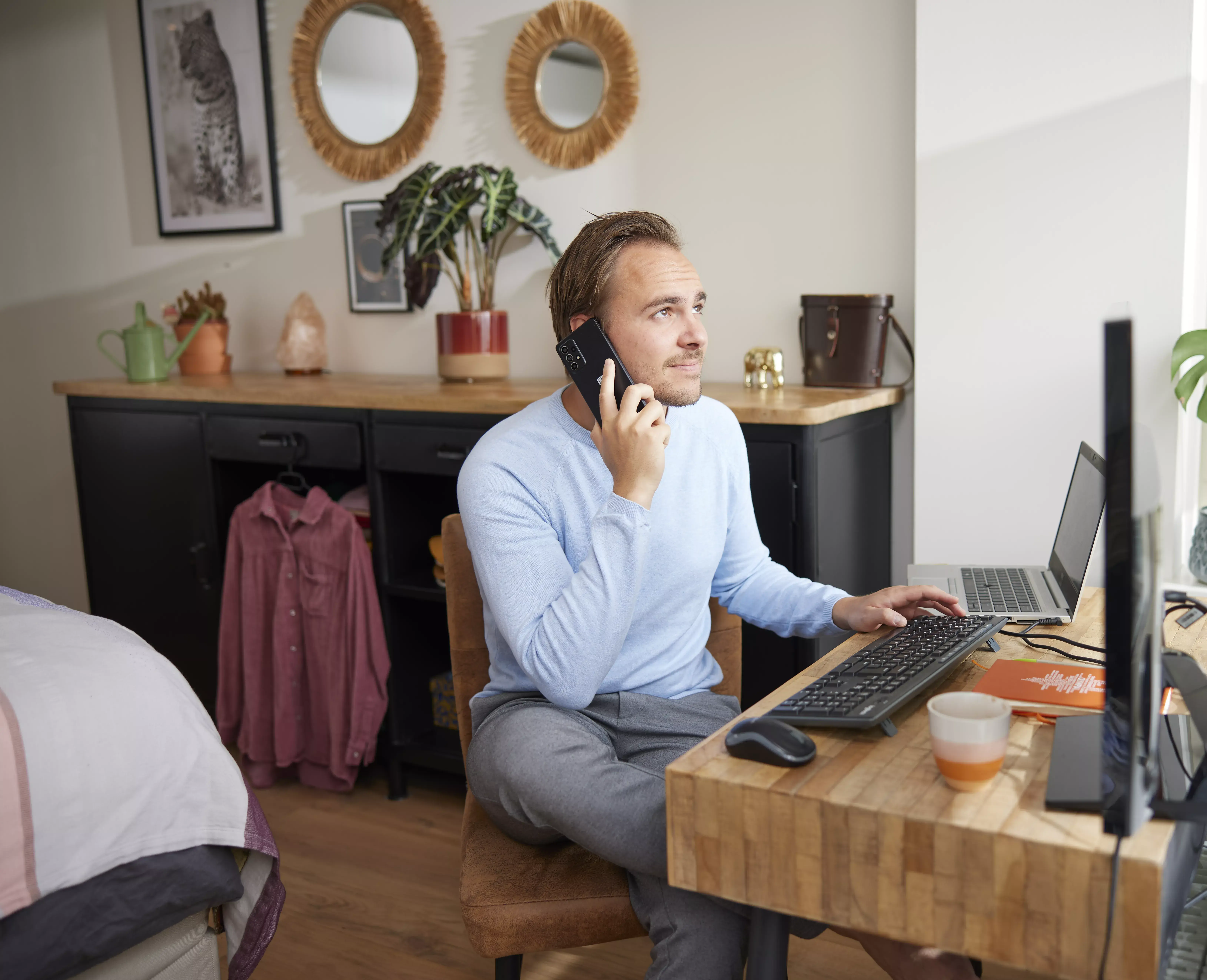 man bellend achter zijn bureau aan het thuiswerken