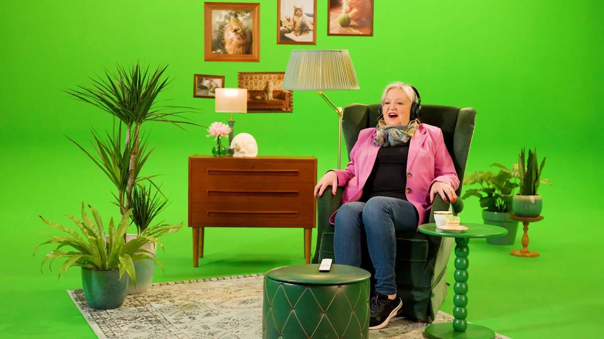 Oudere mevrouw in een stoel met een roze jasje kijkt tv