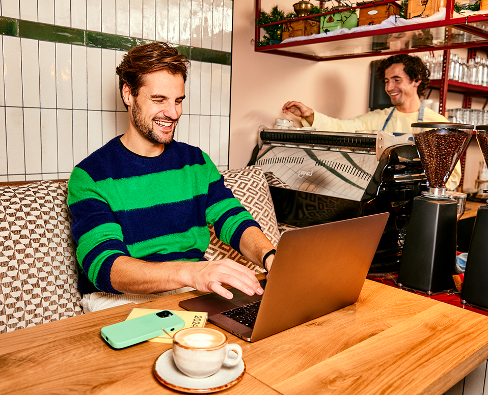 Man zit in restaurant cafe en werkt aan tafel op laptop 