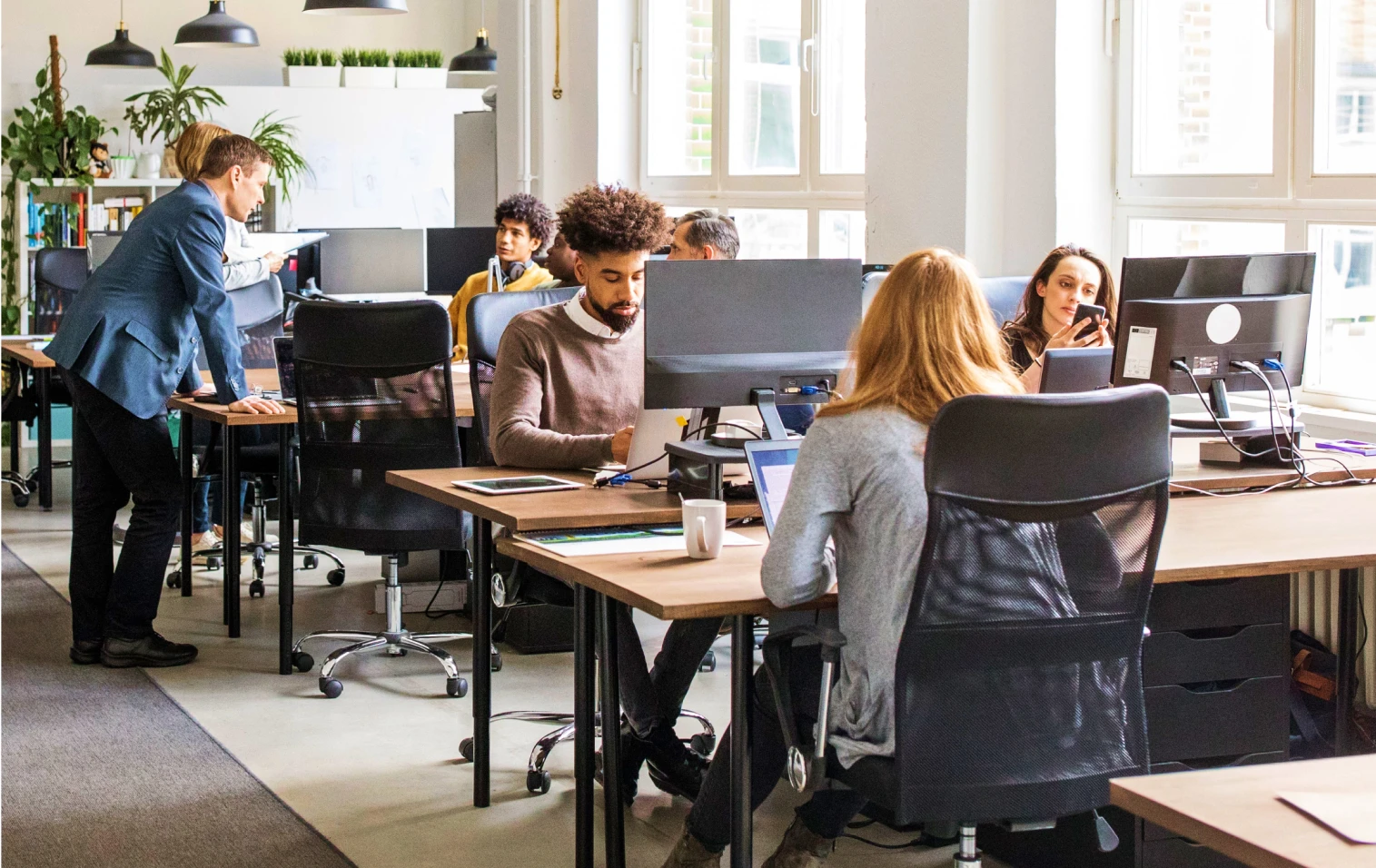 Kantoortuin met mensen die achter hun computer aan het werk zijn