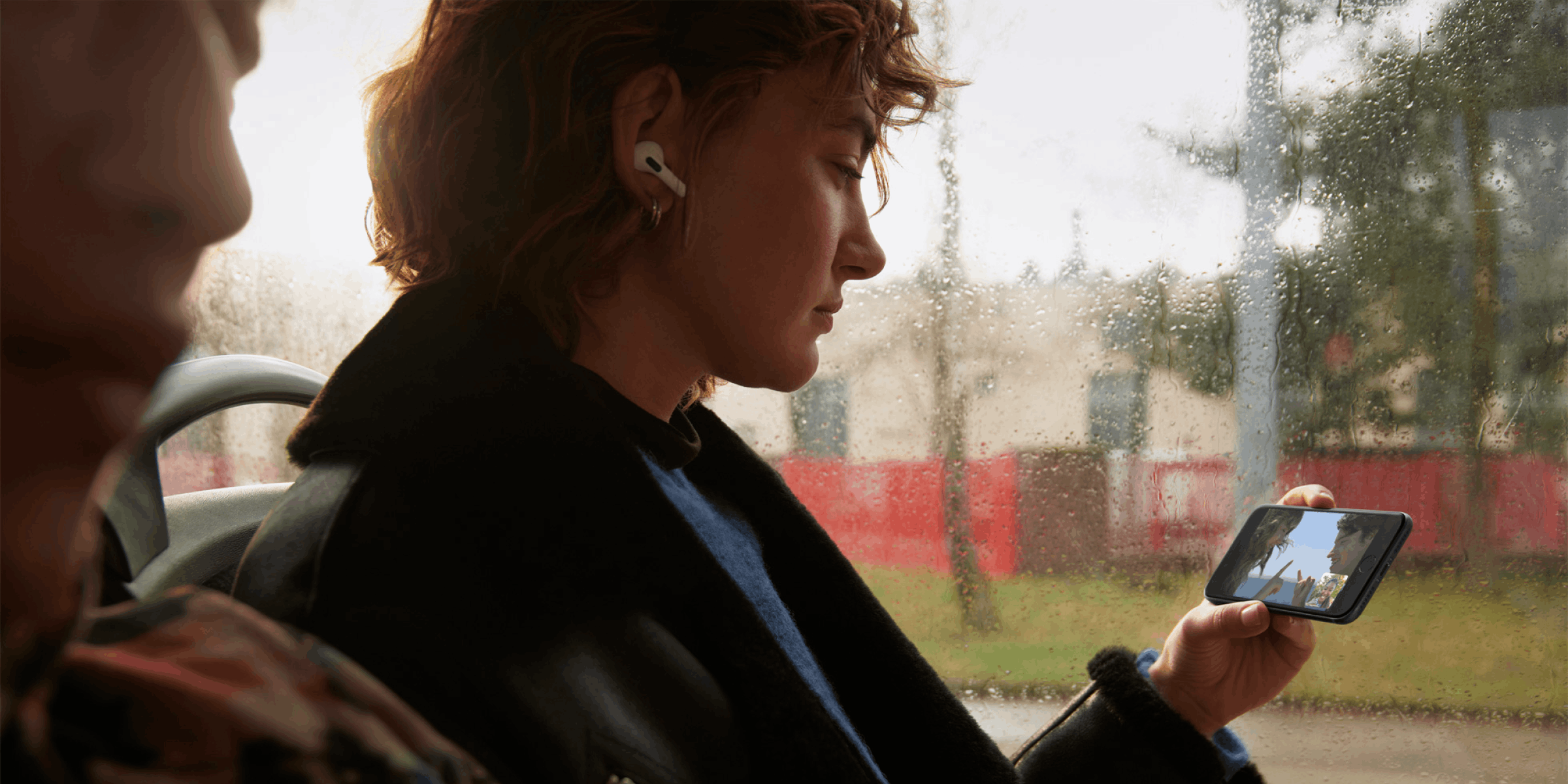 Vrouw die op haar iPhone SE scherm een serie aan het kijken is in de bus