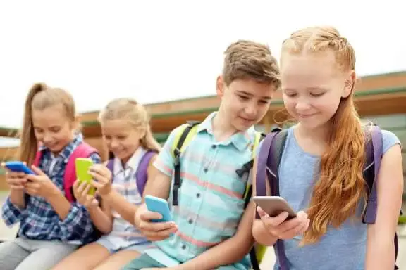 Jeugdige personen zitten naast elkaar en kijken op mobiele telefoon