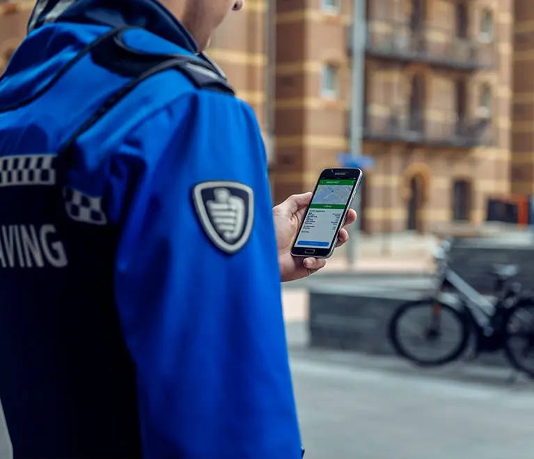 Medewerker van handhaving kijkt een scherm op een mobiele telefoon