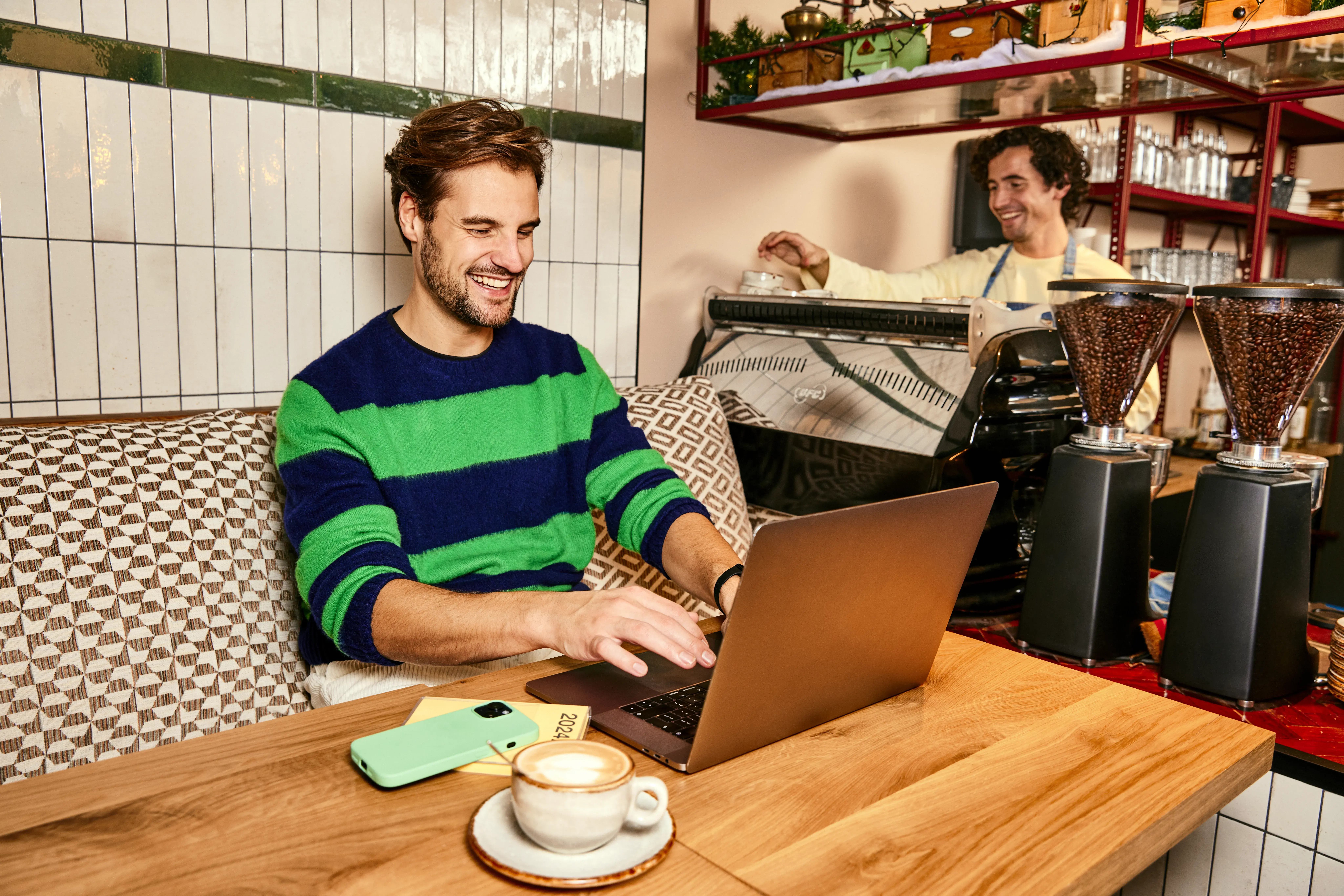 Man aan het werk in koffiezaak op laptop