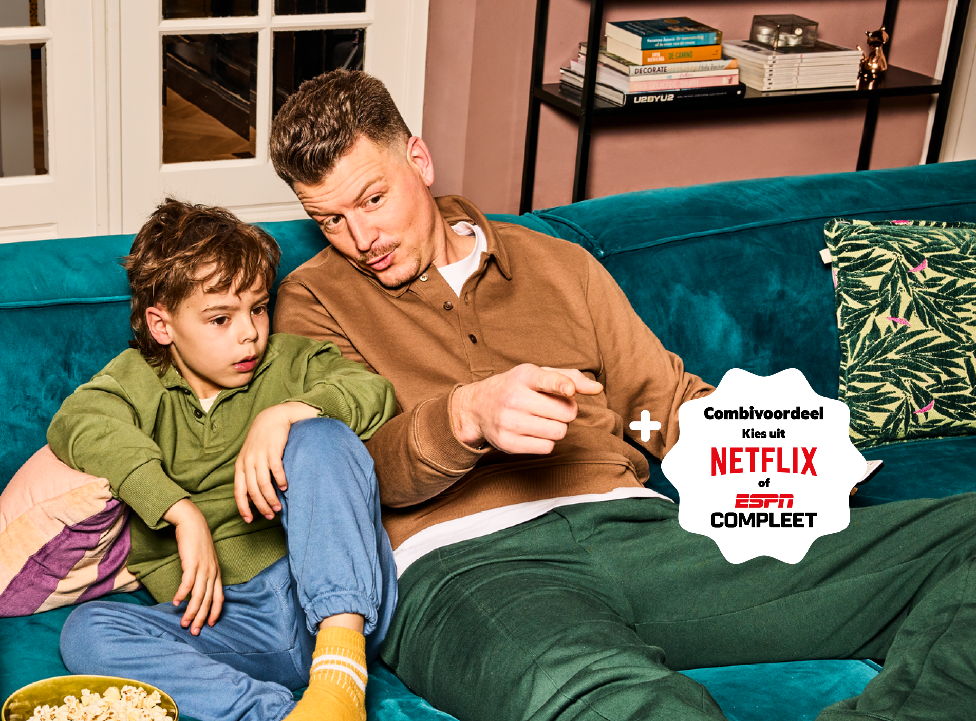 Vader en zoon kijken tv op de bank. Met Combivoordeel kies je uit Netflix of ESPN Compleet.