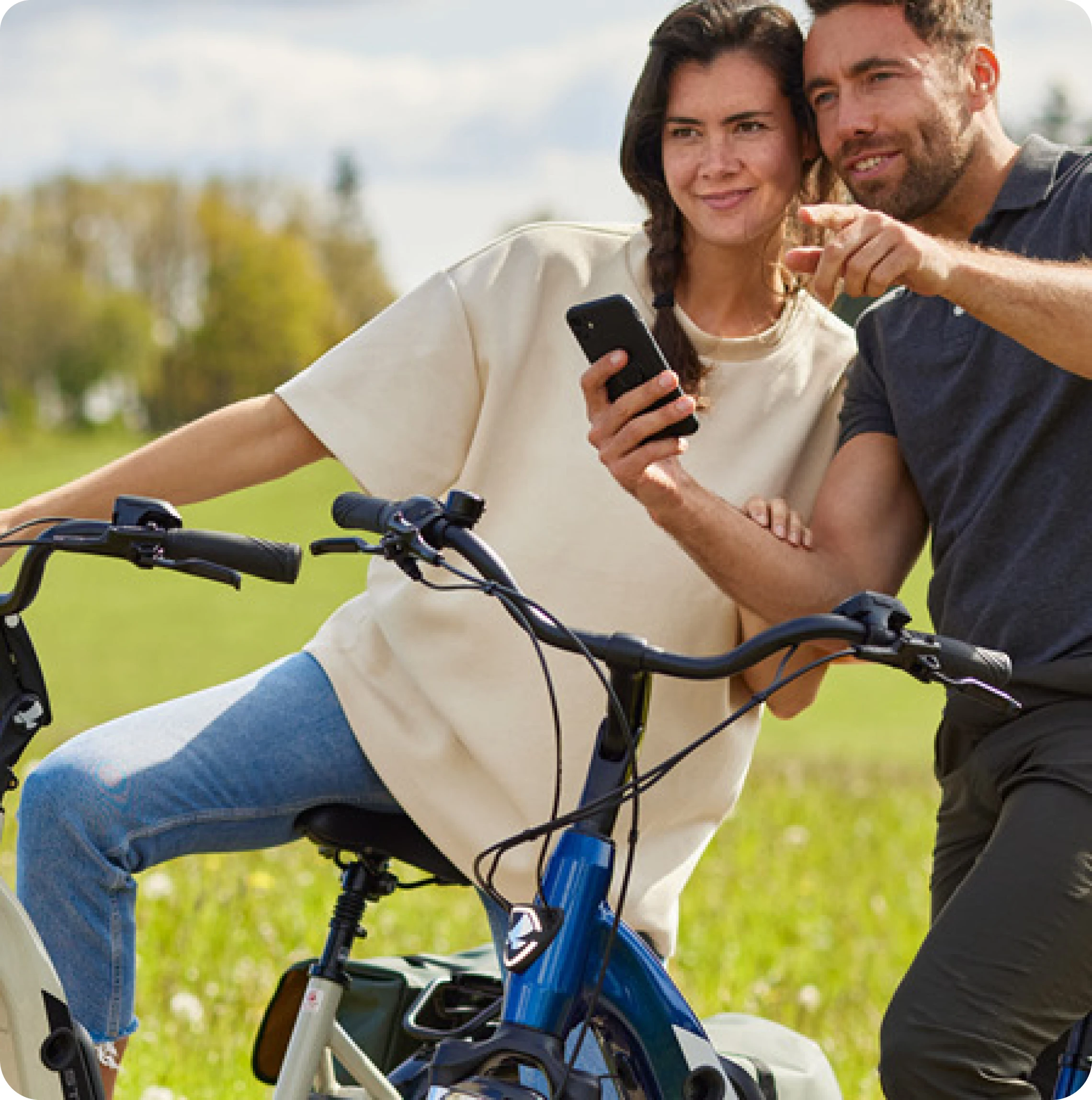 Man en vrouw zitten op de fiets. Man wijst in de verte en vrouw lacht. 