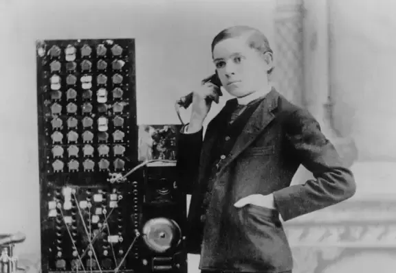 Oude foto van bellende man achter en ouderwtse telefooncentrale