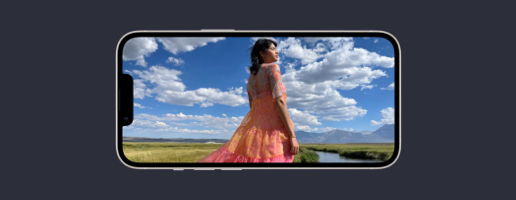 iPhone 13 horizontaal met een afbeelding van een vrouw in een weiland