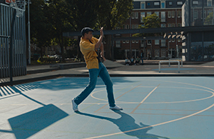 Jongen op een basketbal veld in de stad