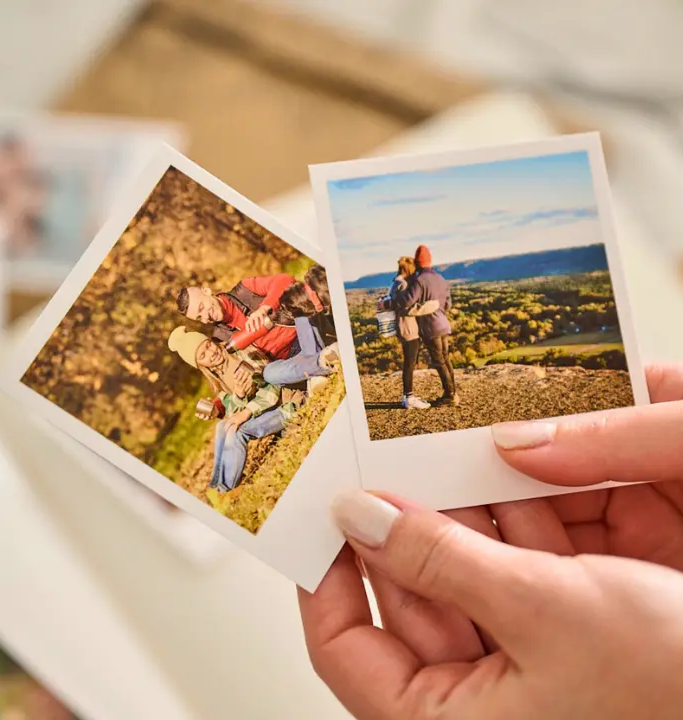 Handen houden polaroid foto's vast
