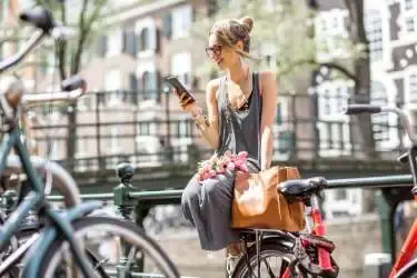 Vrouw op een reling kijkt op haar telefoon