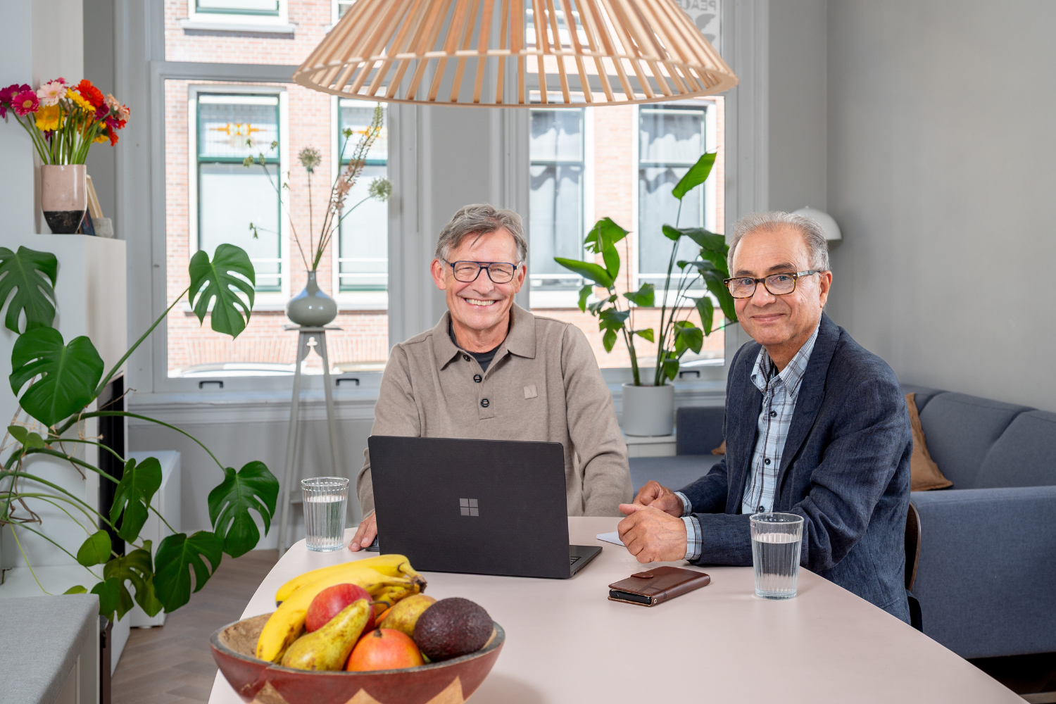 Twee oudere heren achter een laptop