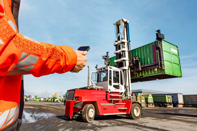 Een man die een container bestuurt via zijn telefoon