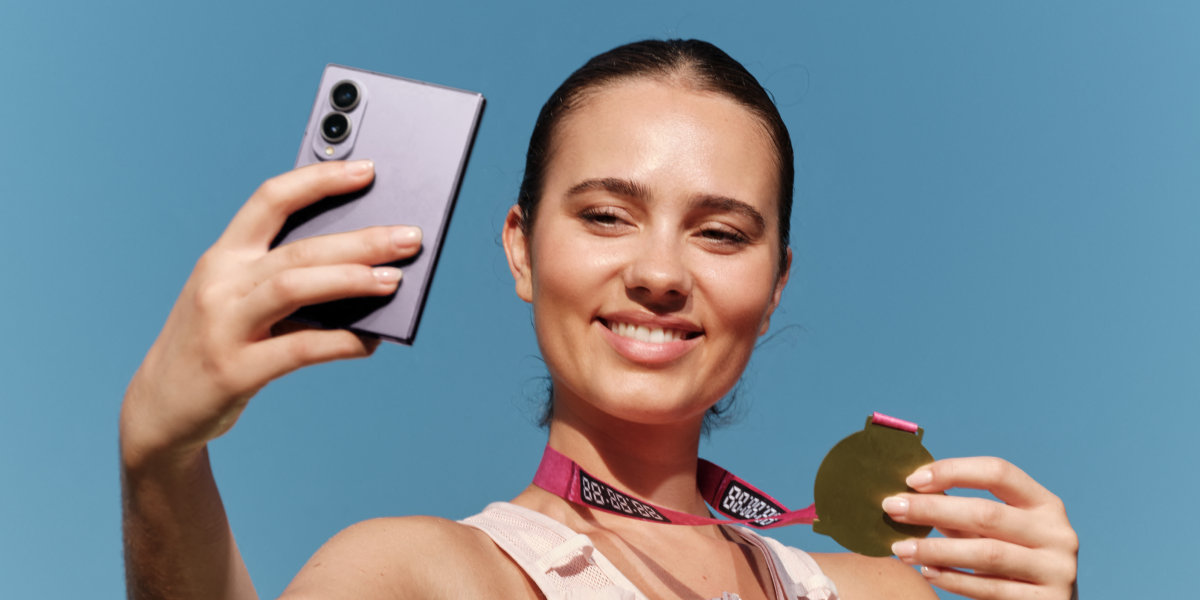 Vrouw maakt een selfie met de Samsung Galaxy Z Fold8  in het paars samen met haar medaille 