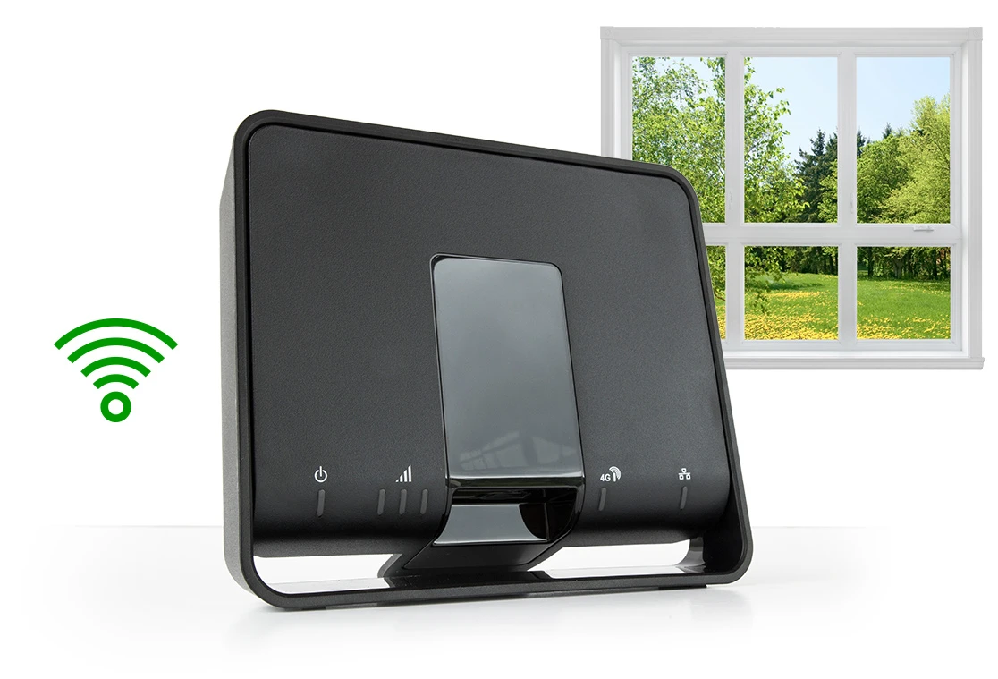 Zwart 4G-modem met een wifi-icoontje en een raam met uitzicht op een bos.