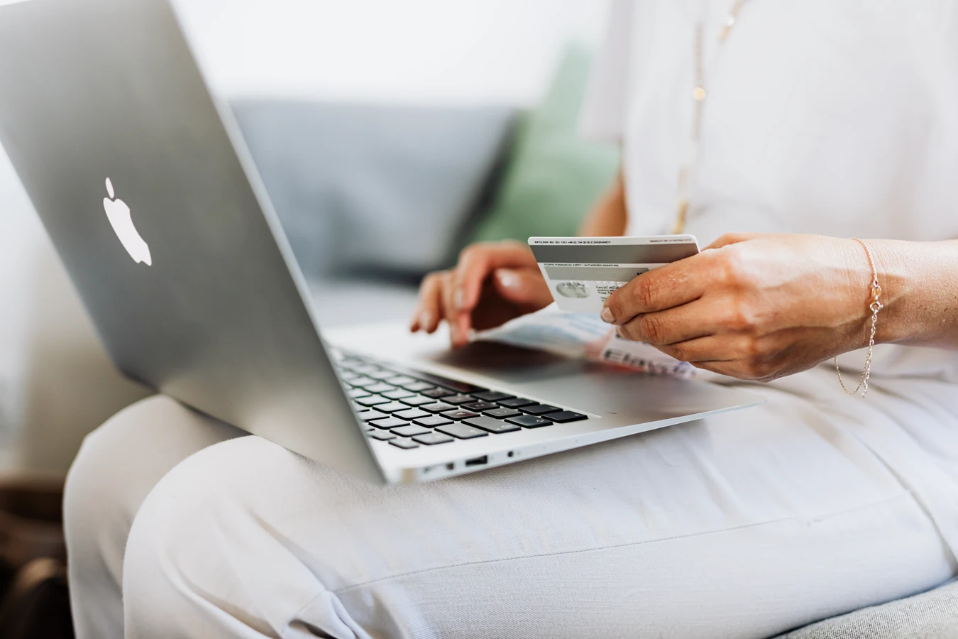 Woman typing in her computer with debit card
