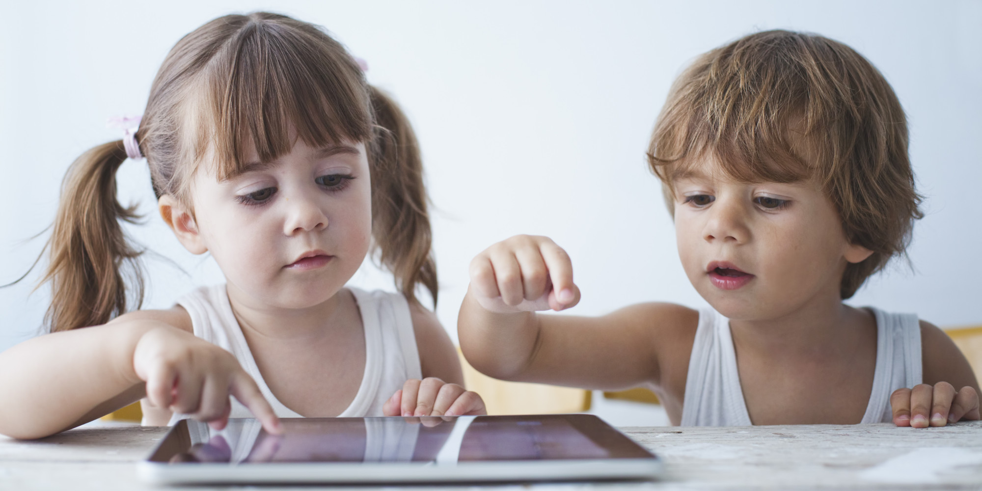 Two small kids using a tablet