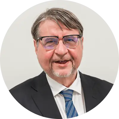 Gerard Baillely, Senior Vice President of R&D, smiling looking towards the camera, wearing a suit.