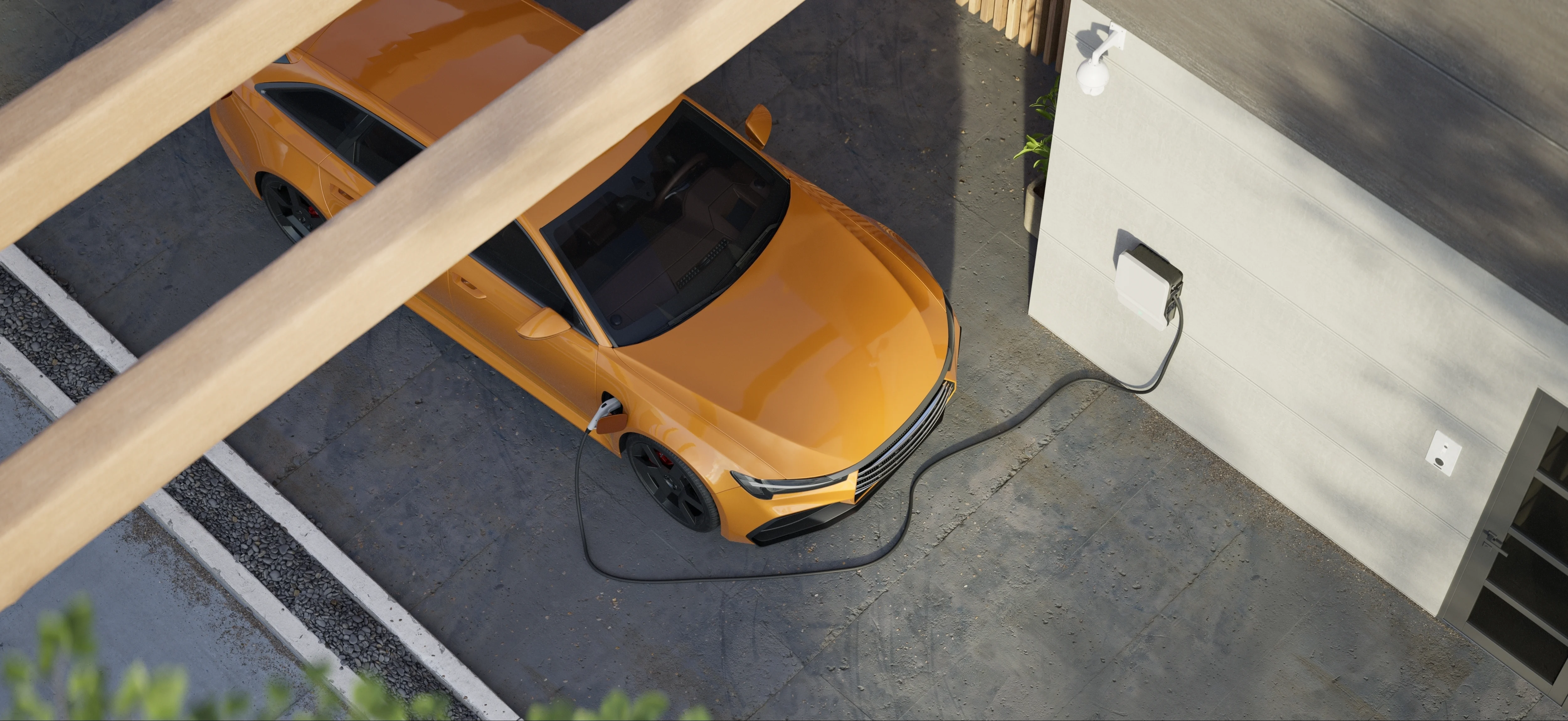 Voiture orange en train de se charger sur un chargeur à domicile, avec un câble de charge connecté.