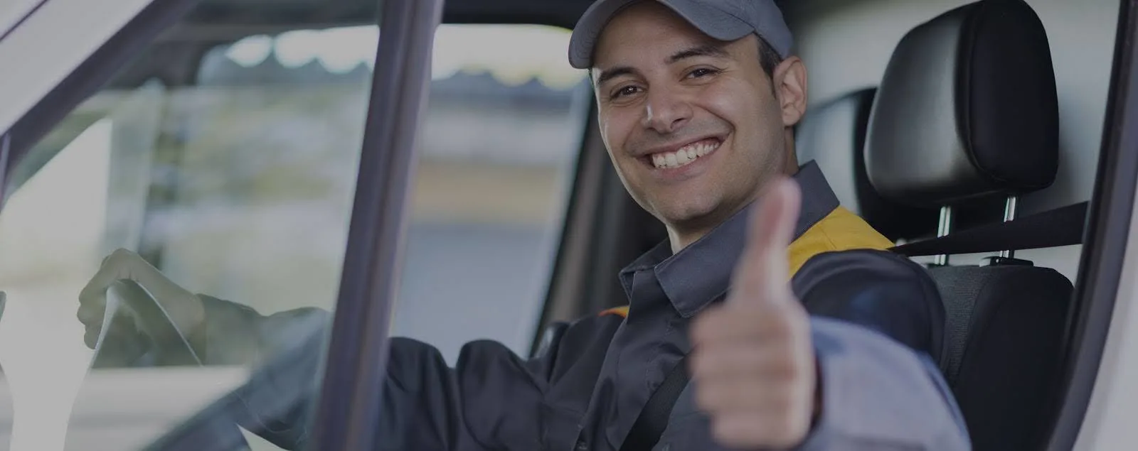 Un conducteur souriant lève le pouce vers le haut après avoir utilisé sa carte carburant.