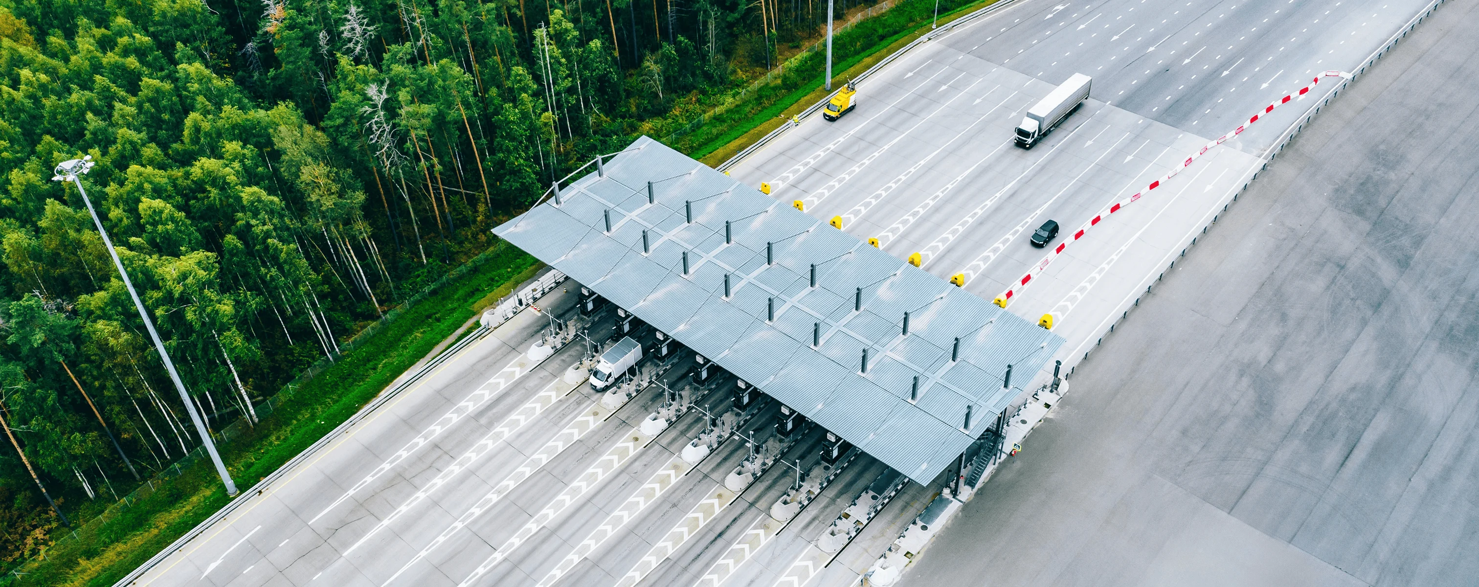 Luftaufnahme einer Mautstation auf einer Autobahn mit LKW und PKW
