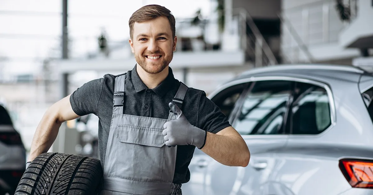 Ein Mann lächelt in der Autowerkstatt.