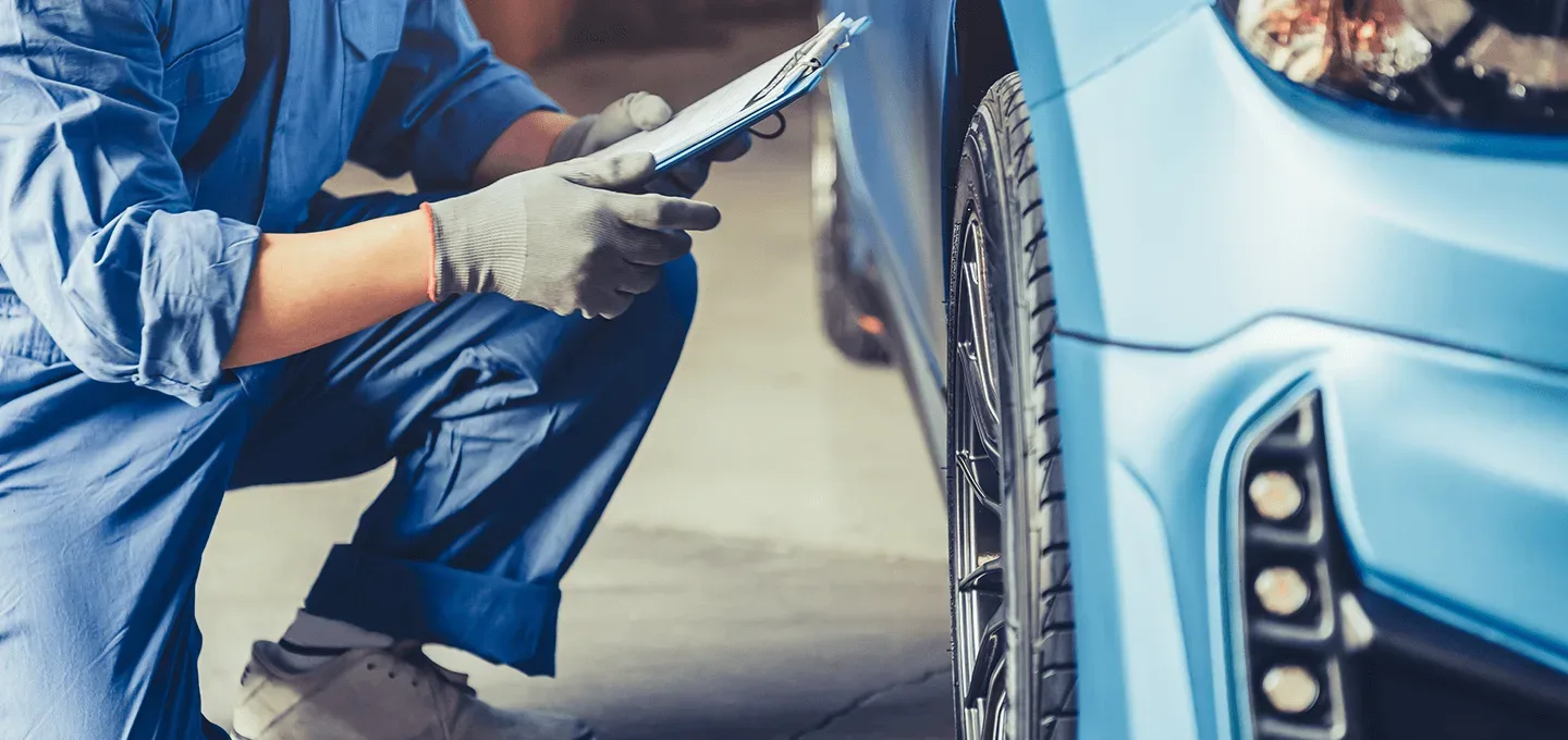 Een monteur controleert de auto.