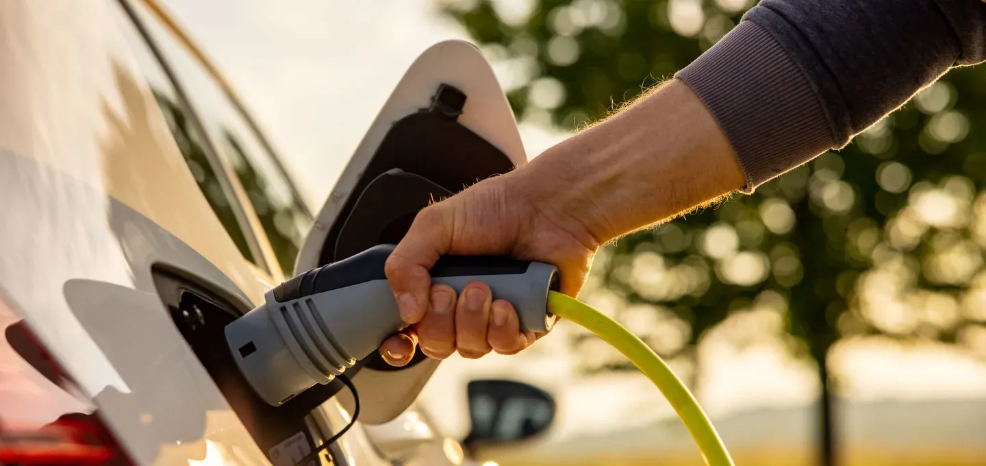 Een elektrische auto wordt opgeladen bij een laadstation.