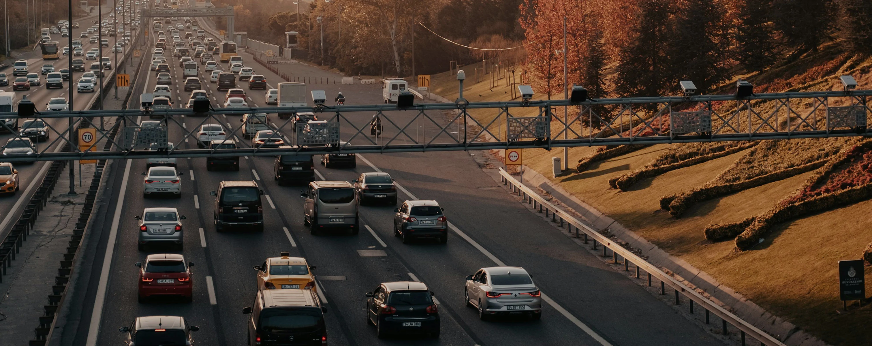 Ruch uliczny na zatłoczonej autostradzie z systemem poboru opłat i kamerami monitoringu.