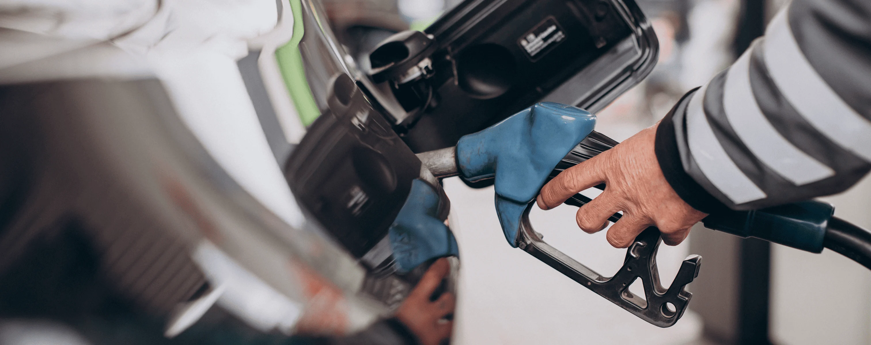 Auto wird an einer Tankstelle mit Kraftstoff betankt.